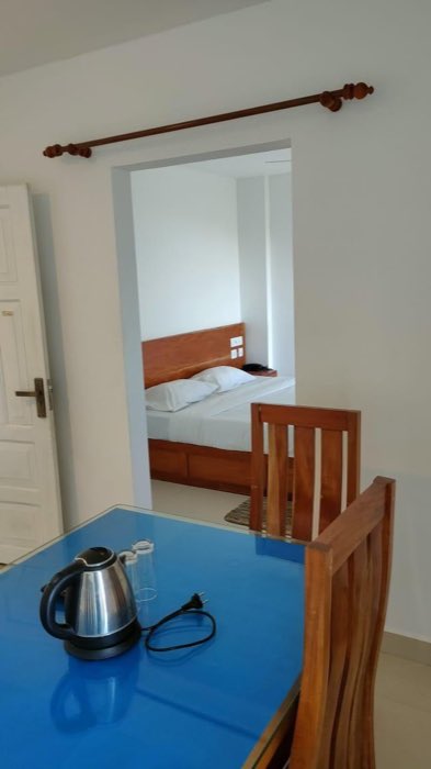 A suite at Vanyora with a separate sitting area and dining table, opening through to the bedroom.